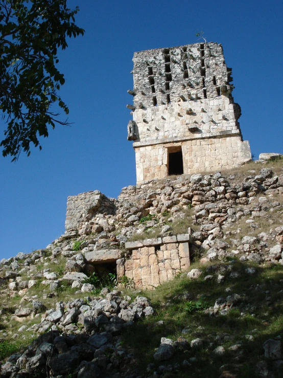 a tall stone tower sitting on the side of a hill