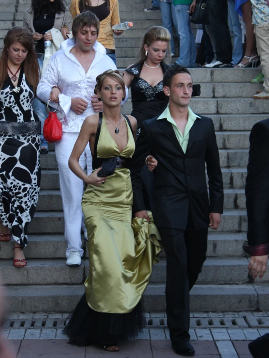 a group of people in fancy dresses walking down stairs