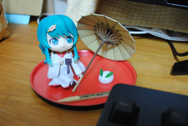 a figurine of a female anime character with an umbrella