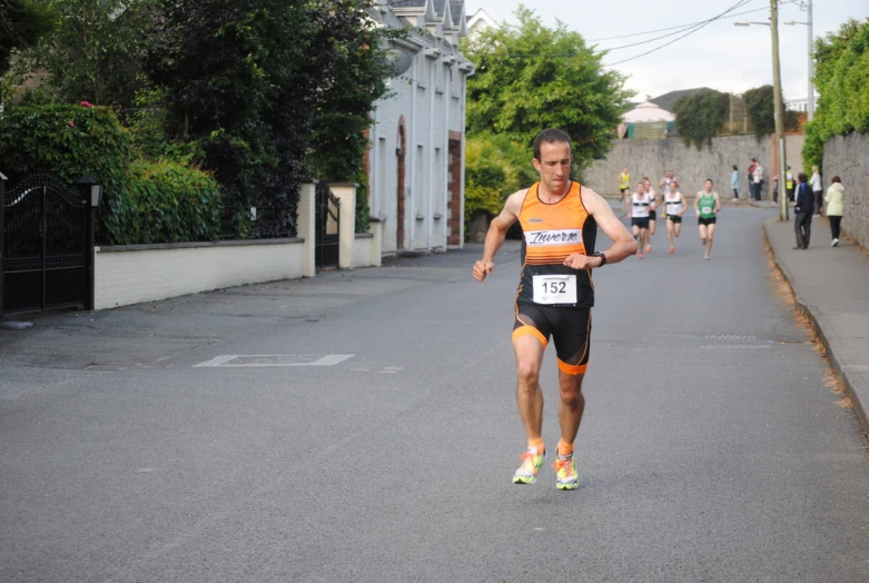 a man is jogging down the street with other people in the background