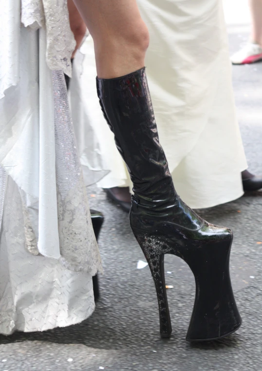 a woman wearing black heels and a white dress