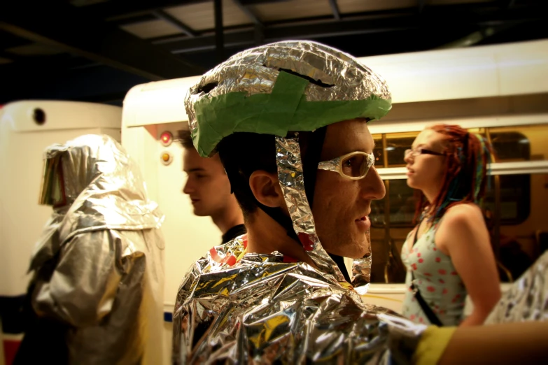 a man with a tinfoil hat on and other people dressed in costume