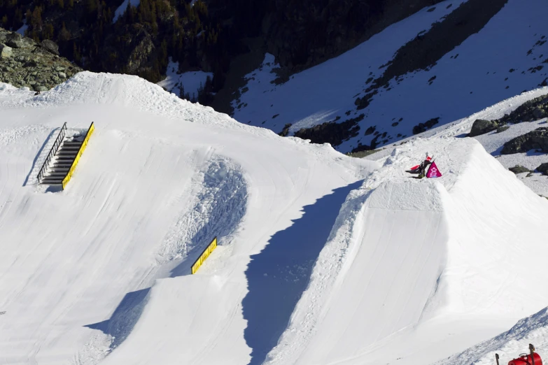 a group of people riding down the side of a snow covered ski slope