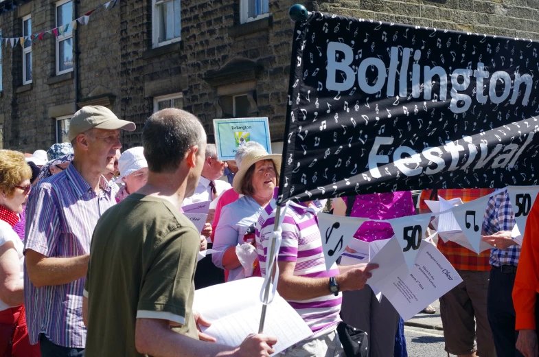 a man standing next to another person holding a sign with a microphone