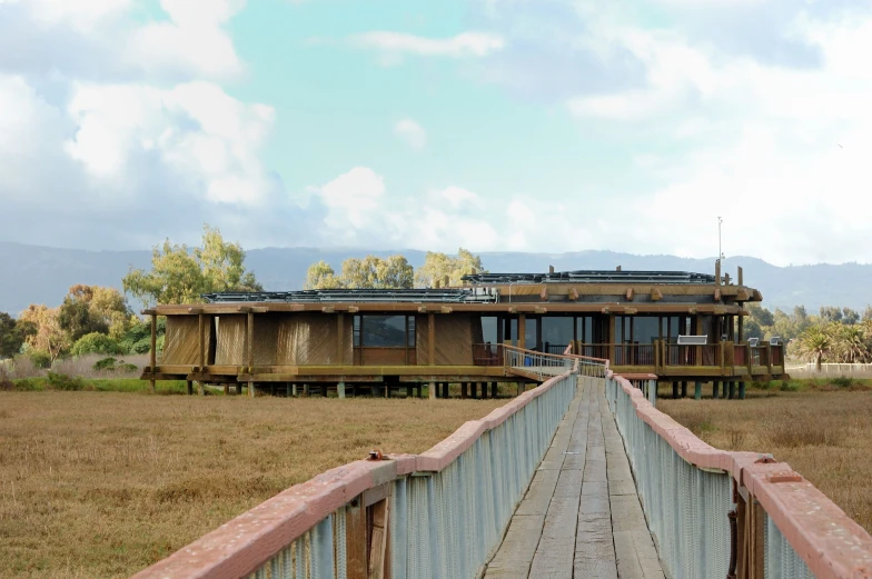 the wooden bridge is going across to a building