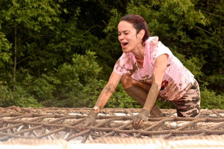 a woman is bending over on a pile of logs