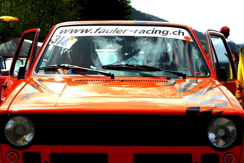 an old orange car is parked on the street