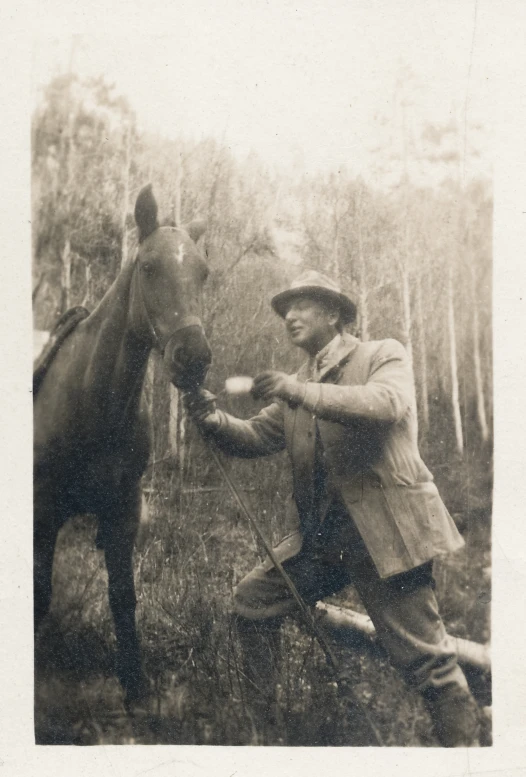 an old po of a man feeding a horse