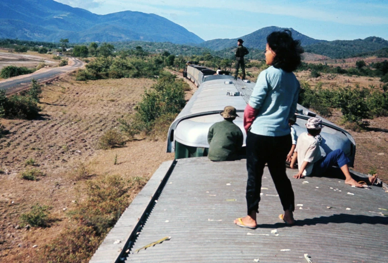 a woman standing on top of a train bridge next to a man