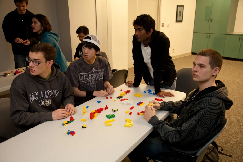 two men at a table playing with legos