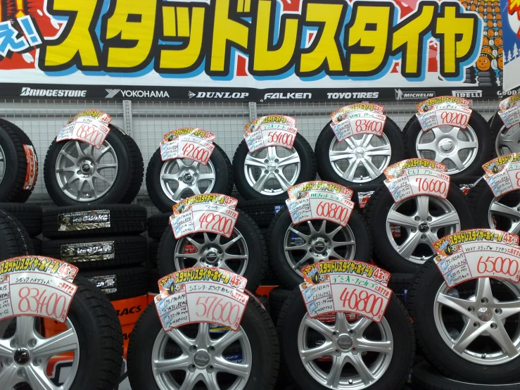 a bunch of tires and tires on display in front of a sign