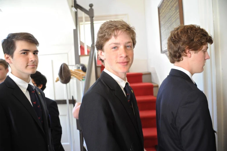 young men are in a line looking at the camera