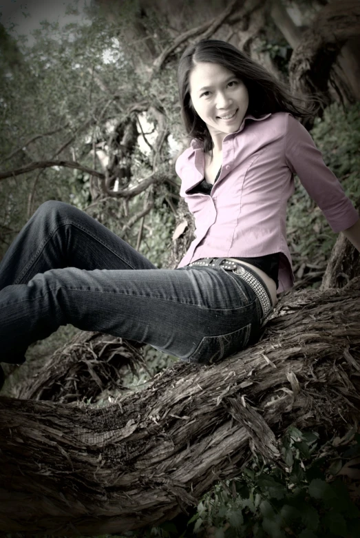 a  posing for her high school picture in a tree