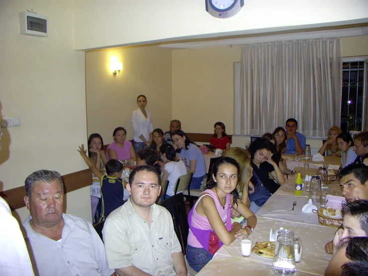 the group of people is sitting at the tables having a meal