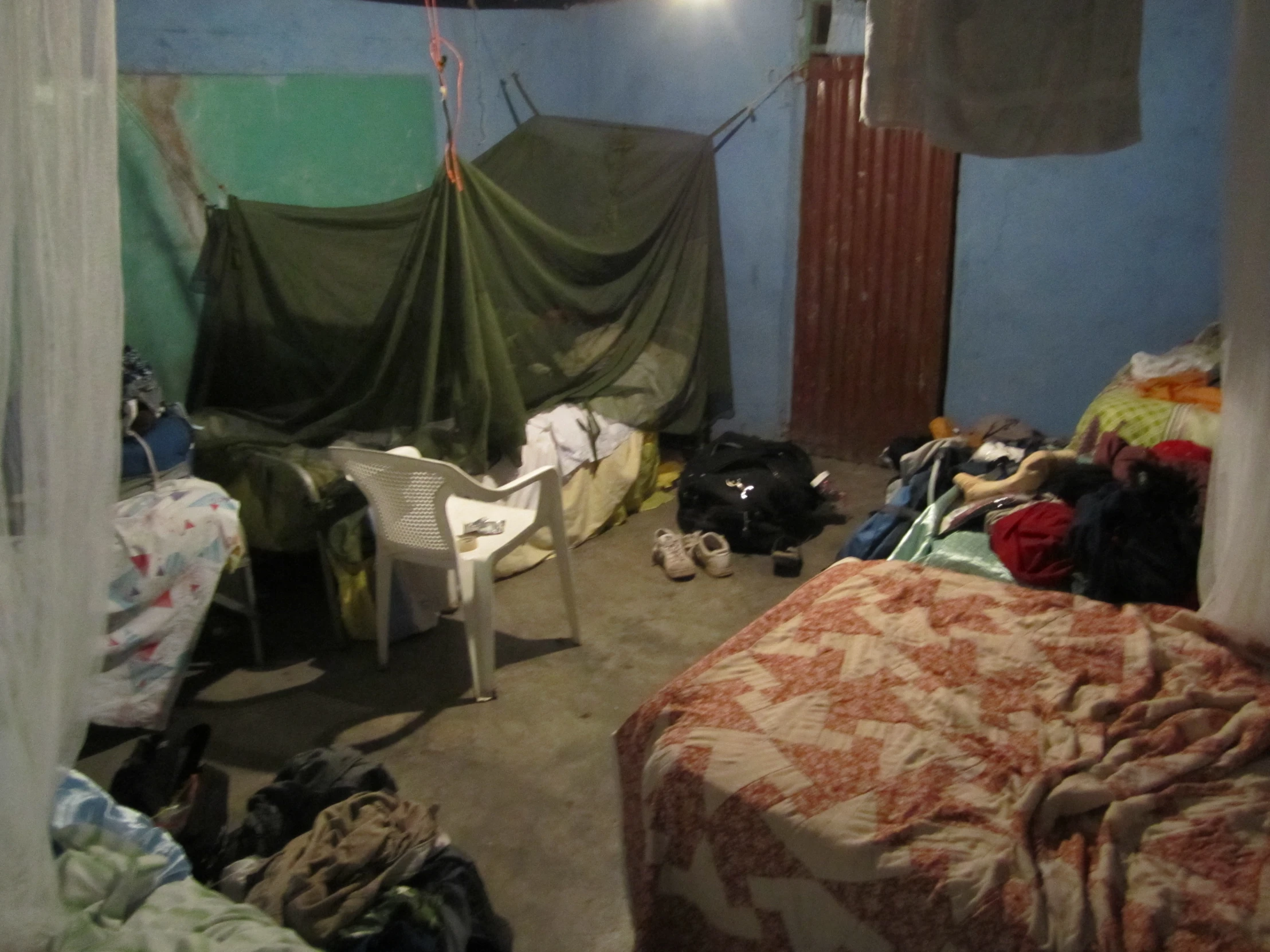 a messy bedroom with messy beds and messy chairs