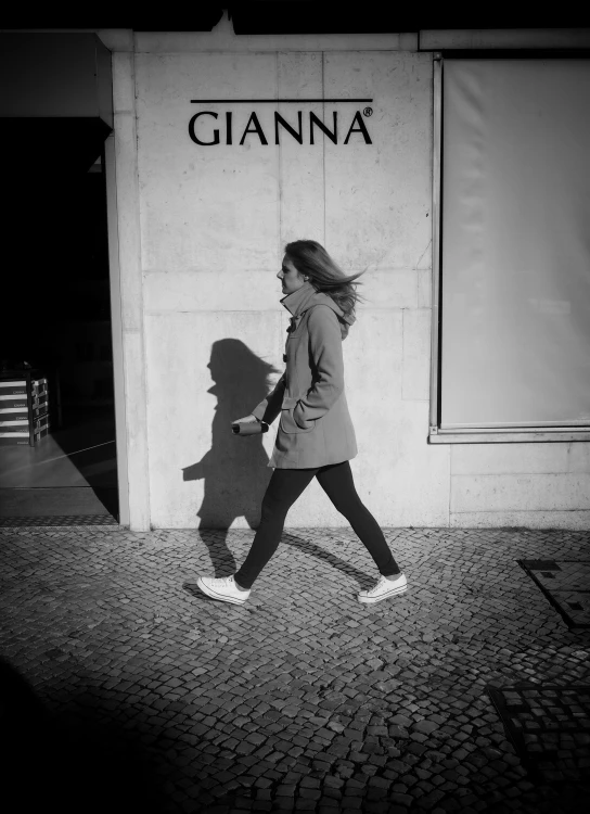 a young woman walks past a giant sign