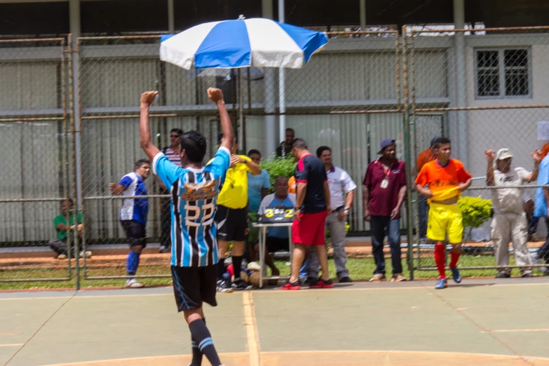 a boy is playing basketball and raising his hand