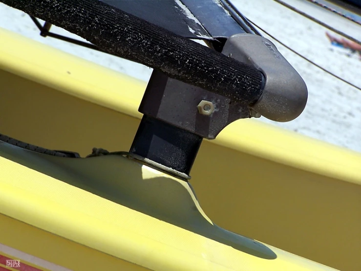 a boat with a yellow and red hull sitting on water