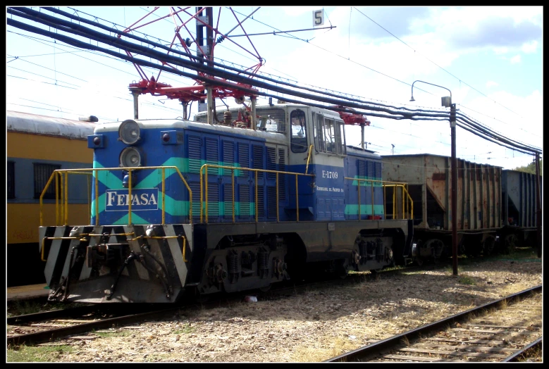 a train that is sitting on the tracks near wires