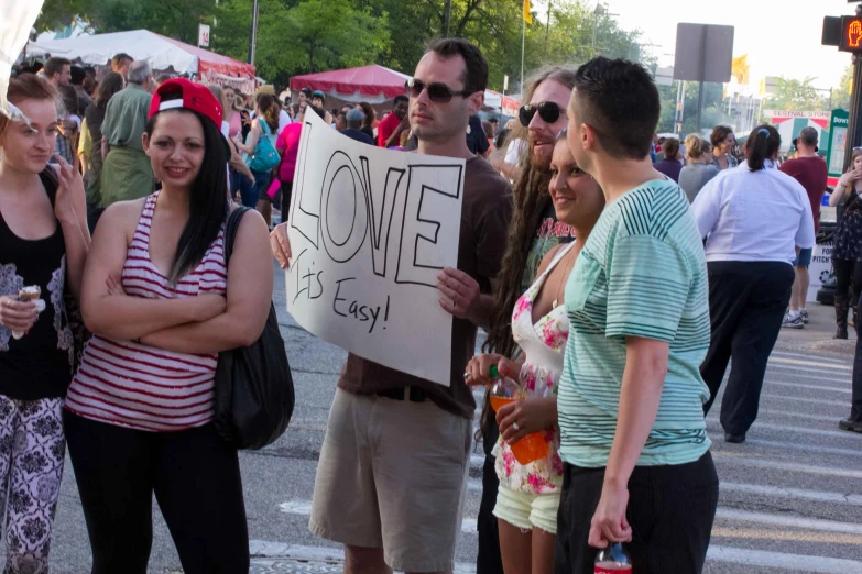 a group of people standing around a cross walk holding signs