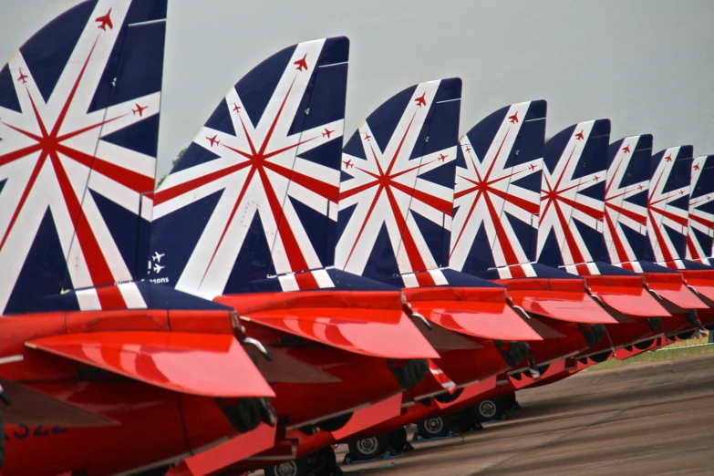 the rows of airplanes sit in a row on the runway