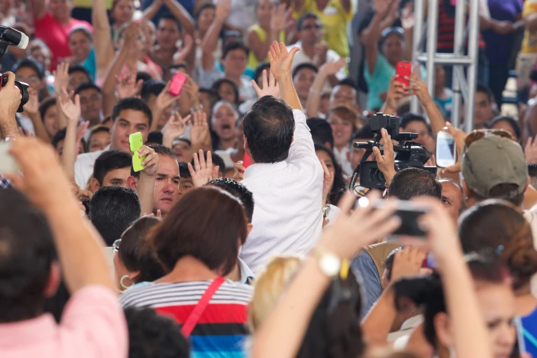 large group of people on the street with their hands up