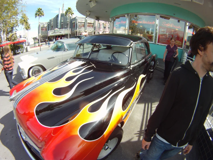 the classic car is painted like a fire and flames