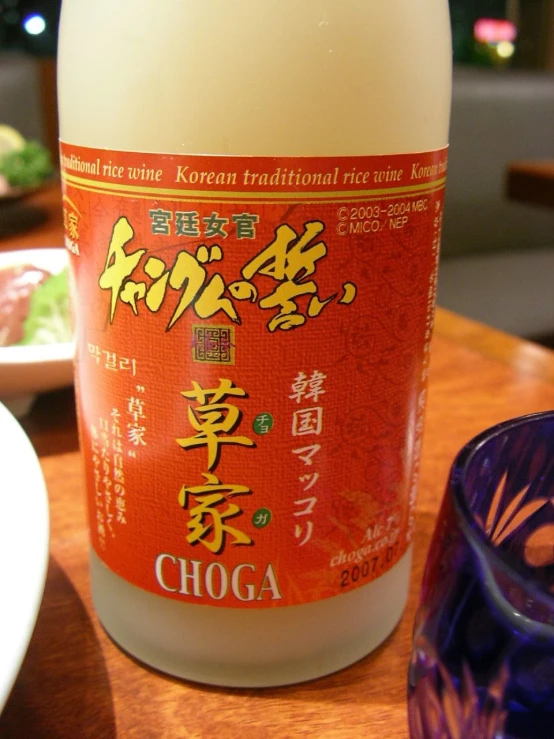an orange bottle with oriental writing sits on a wooden table