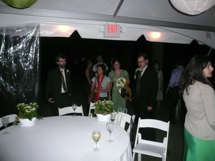 people stand around a table at a wedding