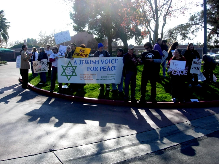 a group of protesters holding a banner on the road