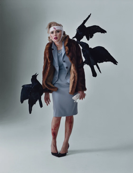 a woman in a coat and black birds