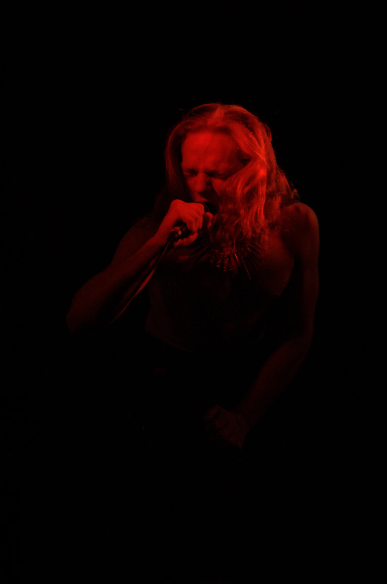 a woman in a black dress is holding a microphone