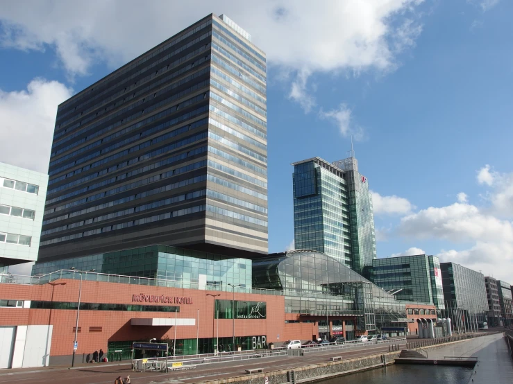 a large building stands tall above other buildings on the waterfront