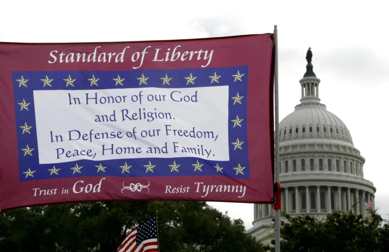 a flag and a giant flag on the street with the capital building in the background