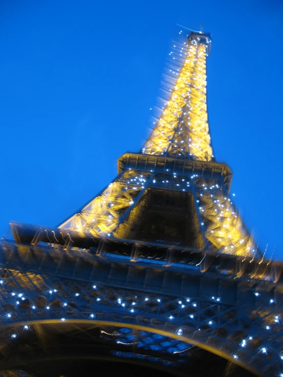 the eiffel tower is lit up yellow and blue