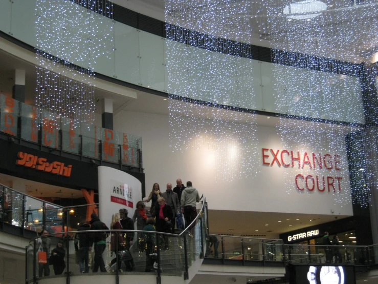 people gathered around on the escalators in a department store