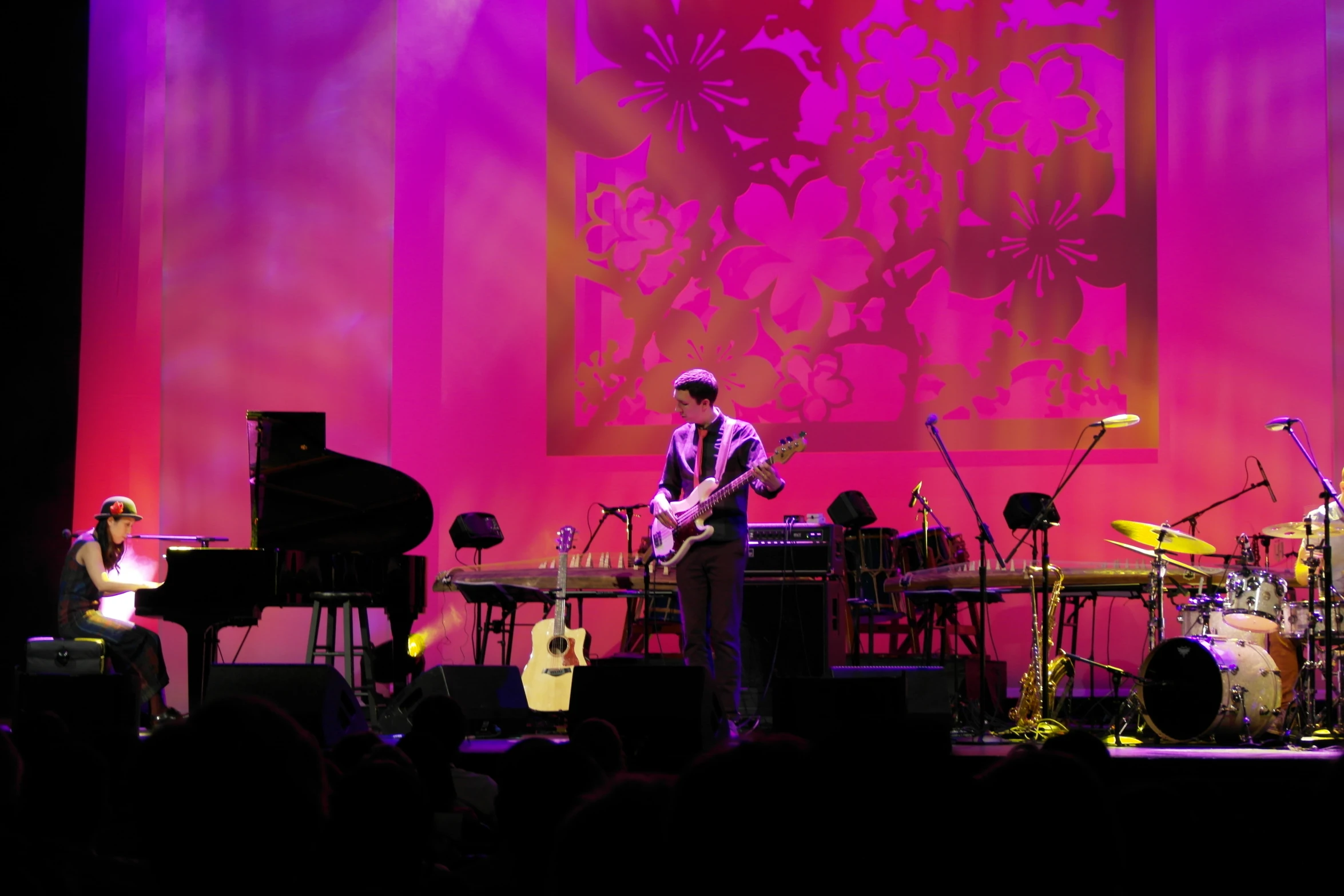 a band performing on a purple and red stage