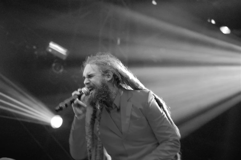 a man with long hair standing on stage