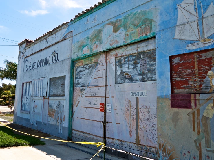 a wall with several paintings on it and some fence post