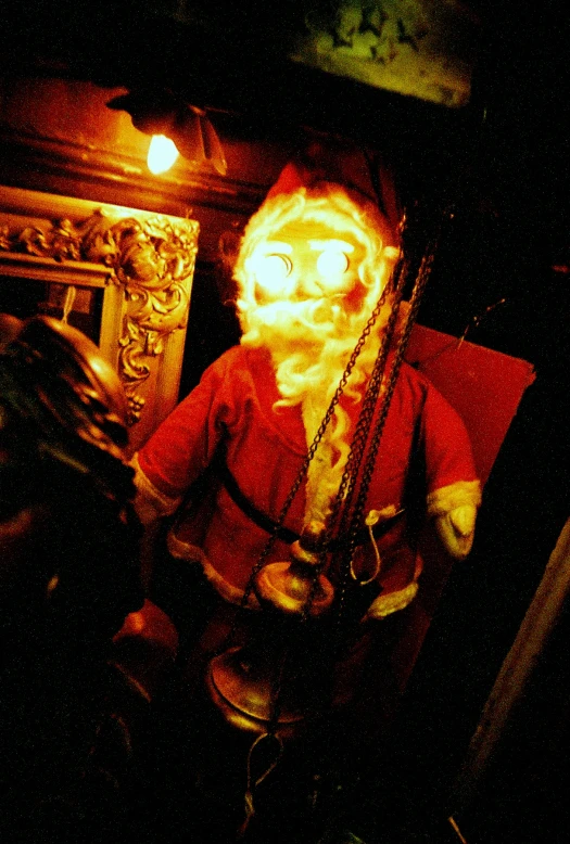 a santa claus in a red costume holding a pair of chains