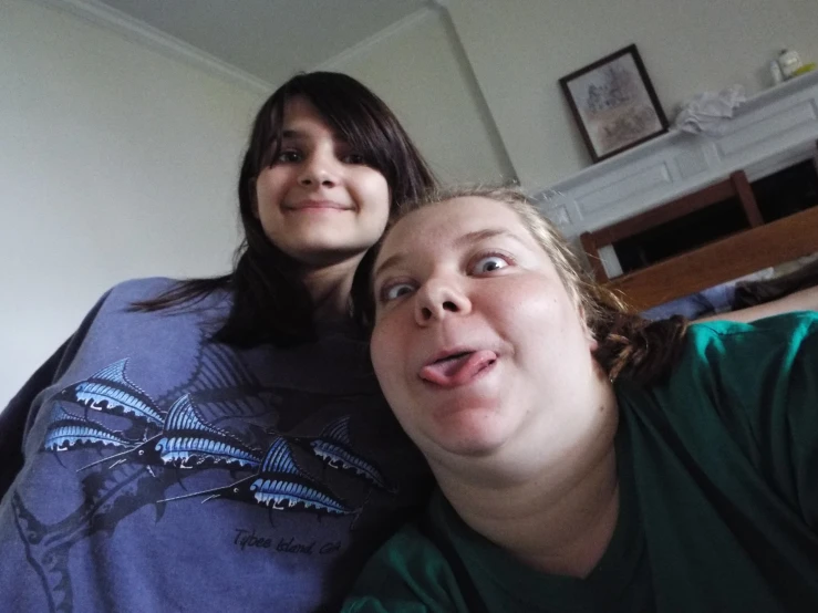 two women posing for a picture with the image on her shirt