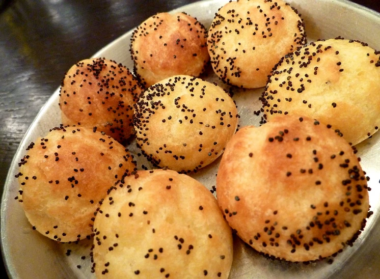 six baked small cakes sitting on a plate