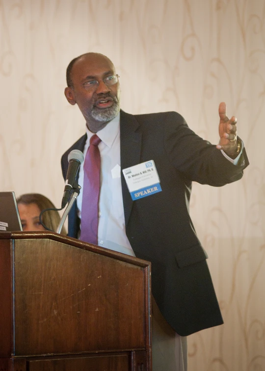 a man talking in front of people with microphone