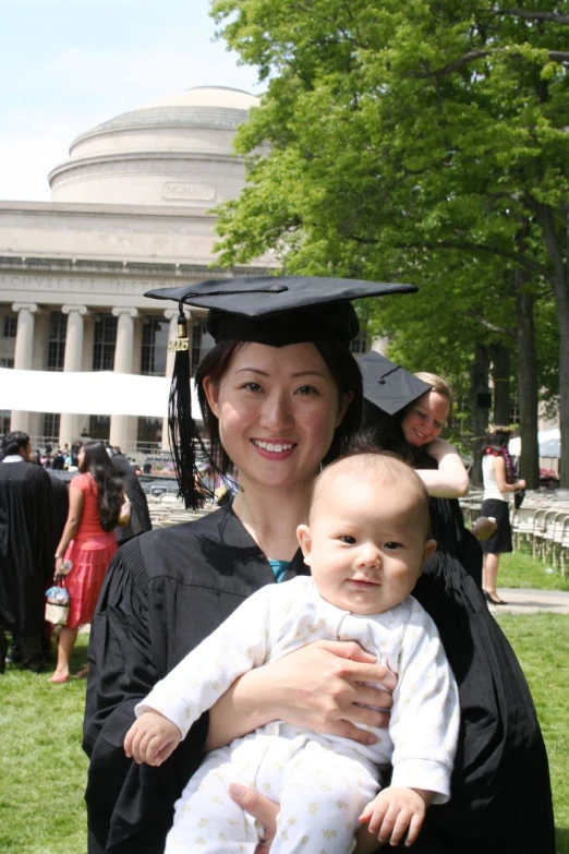 woman in cap and gown holding a small baby