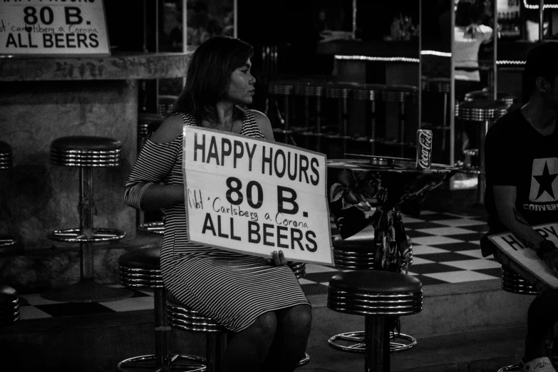 a man holding a sign that reads happy hours 80 and all beers