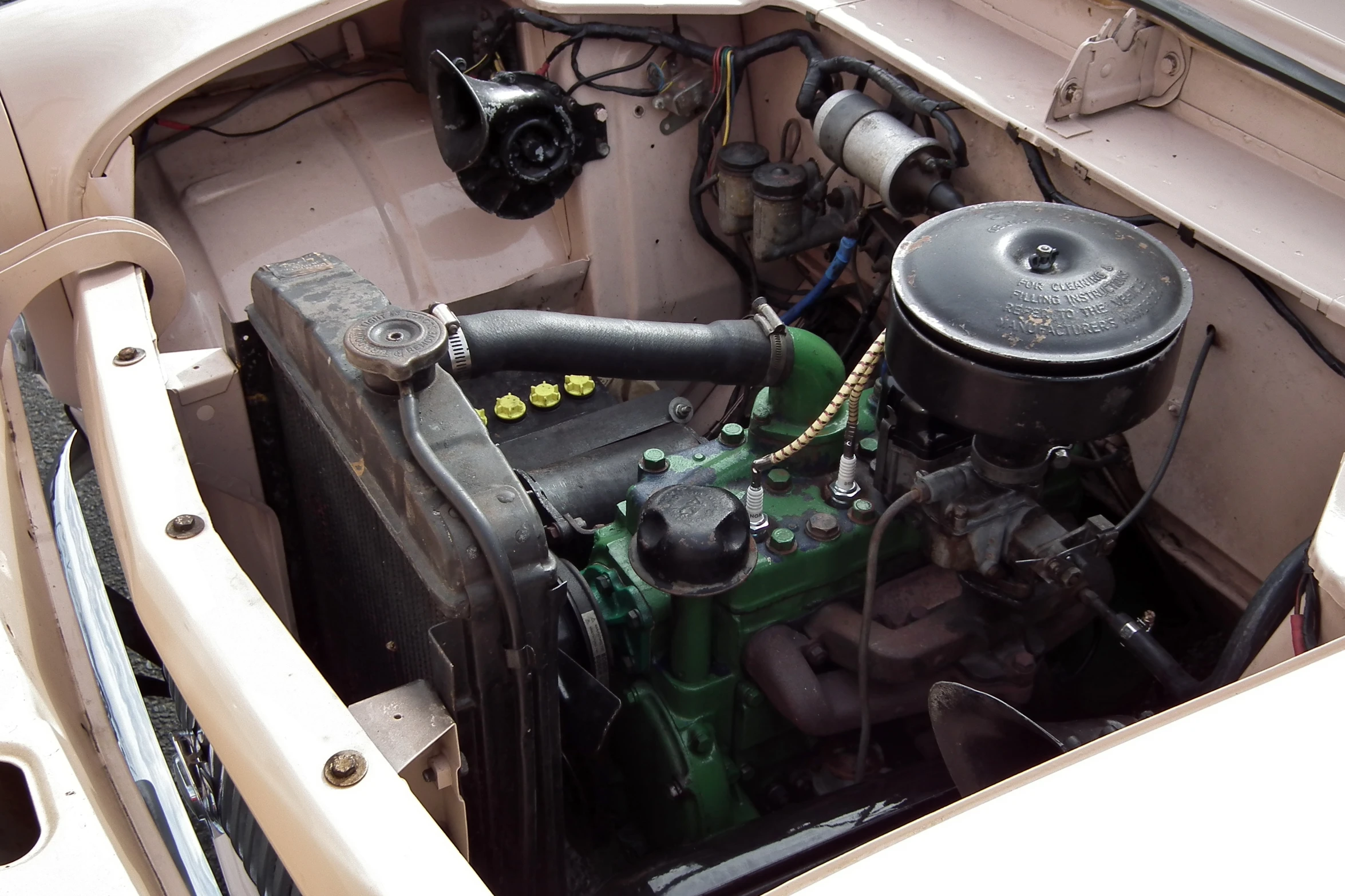 the engine compartment of an old, dirty car