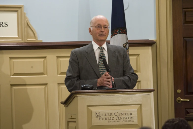 a man standing at a podium while wearing a suit