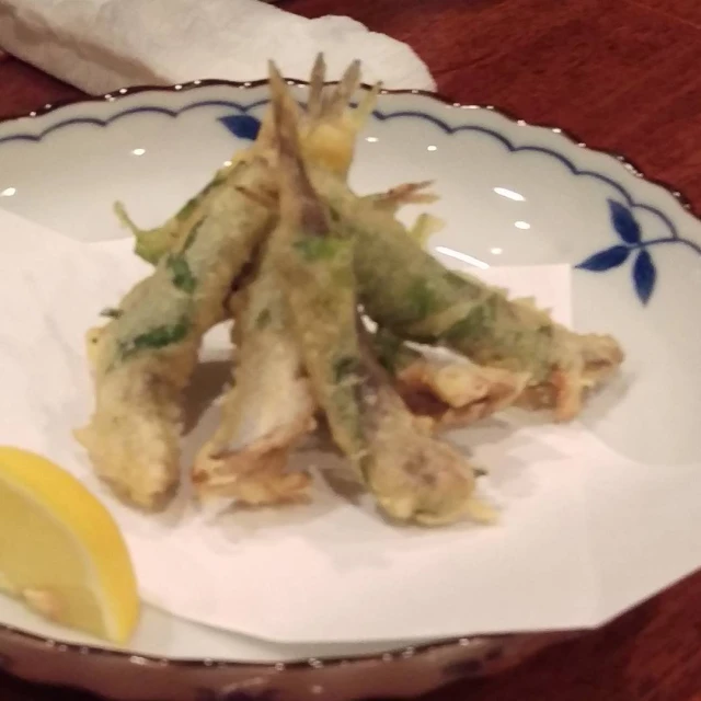 a plate filled with fried food next to a lemon wedge