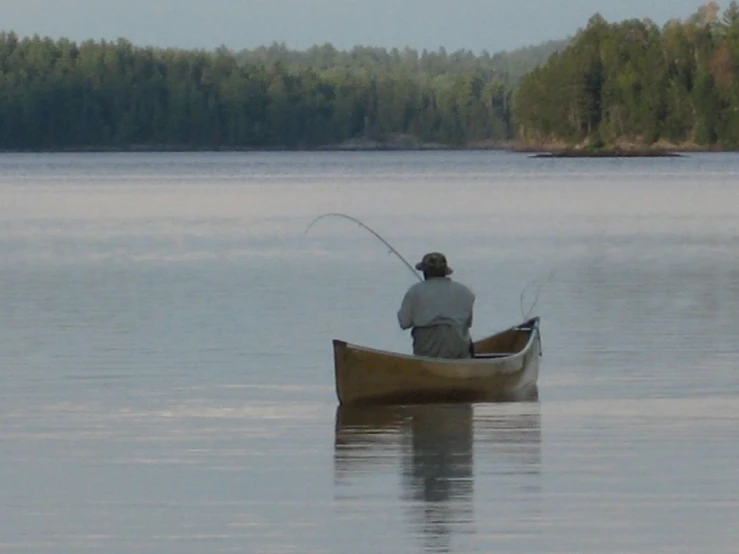 a man that is sitting on a boat with a fishing pole