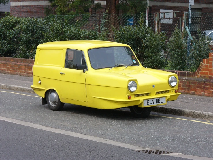 a yellow van on a street with people on bicycles in the background